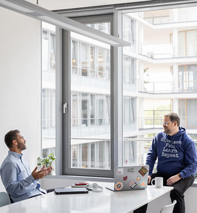 Zwei Mitarbeiter unterhalten sich in einem Büro 