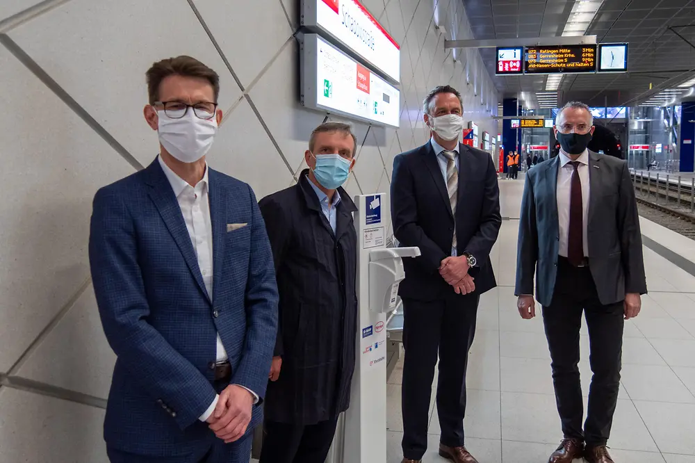 Henkel-Standortleiter Dr. Daniel Kleine, Oberbürgermeister Thomas Geisel, Leiter Standortlogistik BASF in Düsseldorf Dr. Uwe Hömmerich und Vorstandsvorsitzender der Rheinbahn Klaus Klar (vlnr.) bei der Installation eines Desinfektionsmittelspenders an einer U-Bahn Haltestelle der Rheinbahn.