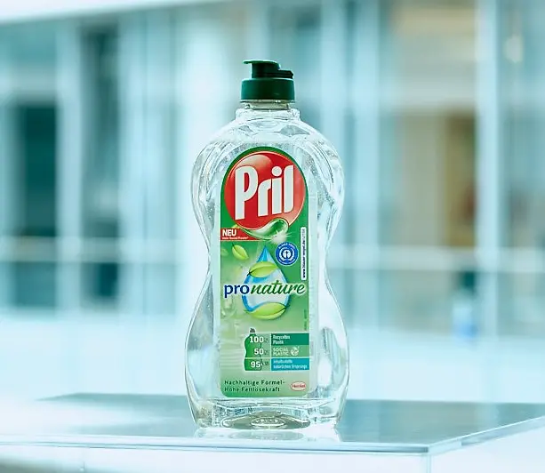Eine Flasche des Geschirrspülmittels Pril Pro Nature steht auf einem transparenten Tisch.