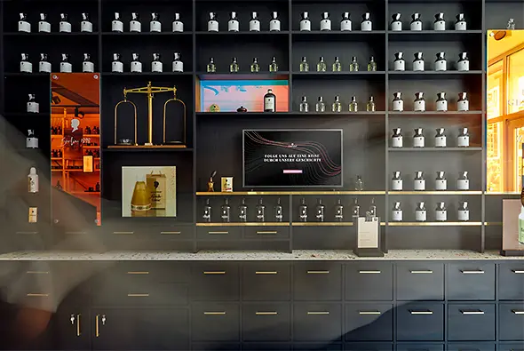 Eine dunkle Regalwand mit goldenen Griffen, auf der Schwarzkopf-Produkten aufgereiht sind.