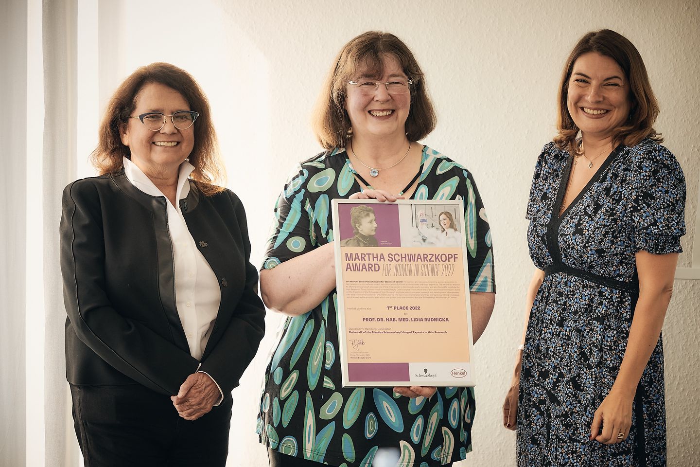 Die Award-Gewinnerin Prof. Dr. hab. med. Lidia Rudnicka steht links von Dr. Andrea Sättler und Sylvie Nicol. 
