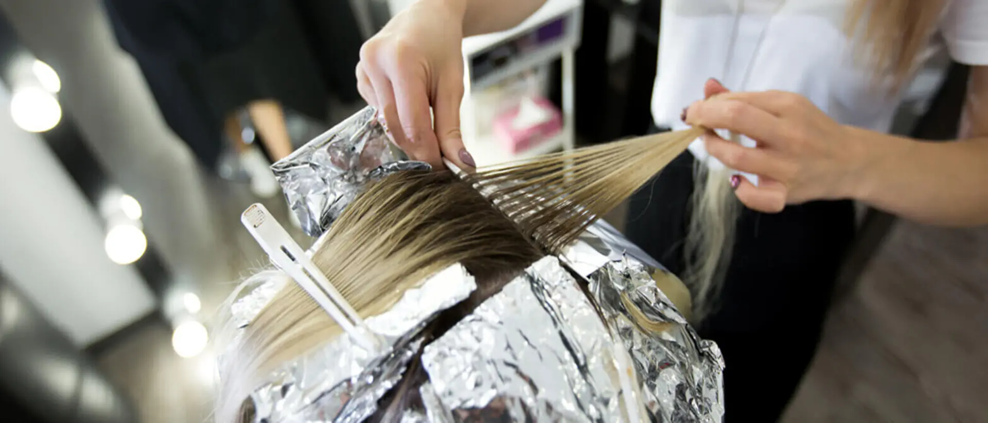 Eine Friseurin schneidet einer Kundin die Haare.