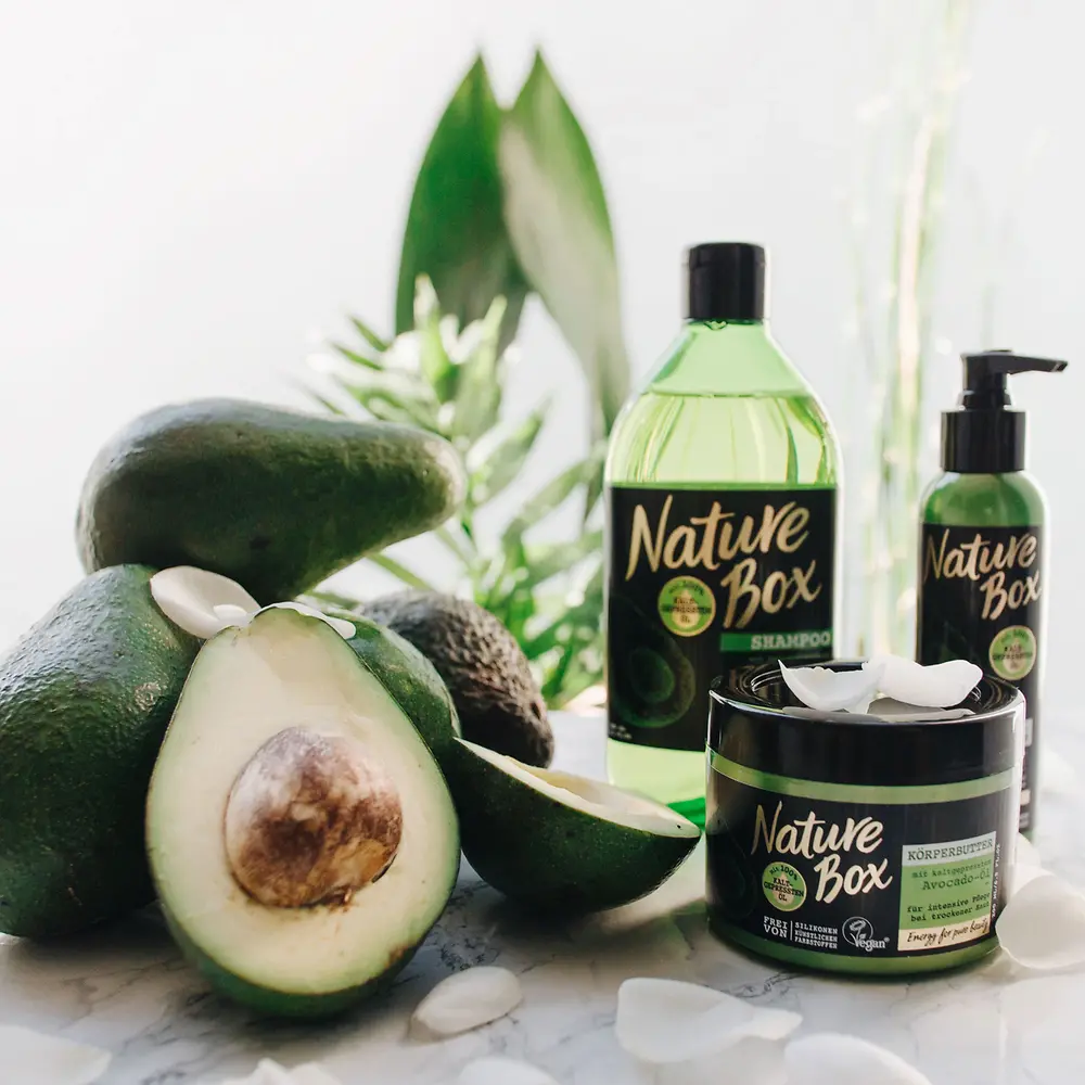 Drei Nature Box-Produkte stehen neben mehreren Avocados.