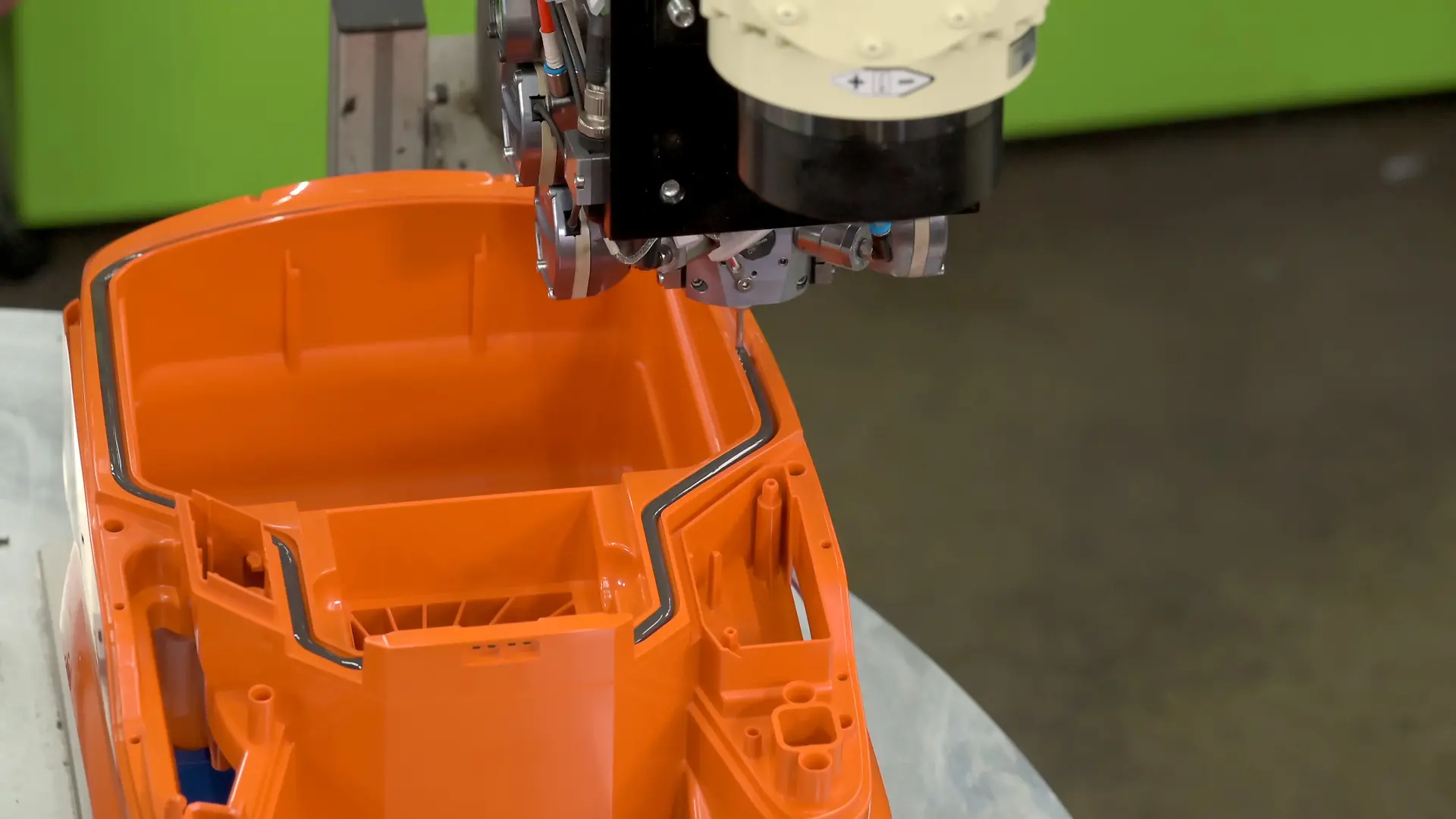 
Der am 6-Achs-Roboter montierte Mischkopf appliziert 2K Polyurethanschaum zum Abdichten des Staubsaugergehäuses in die Nut.