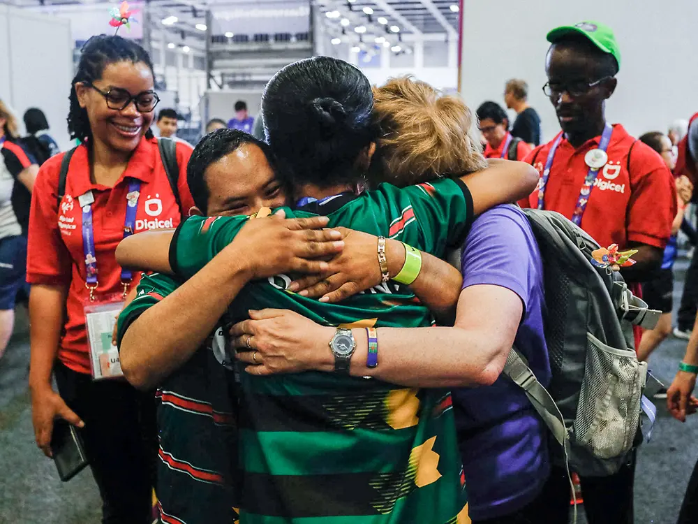 Drei Menschen umarmen sich innig bei den Special Olympics.
