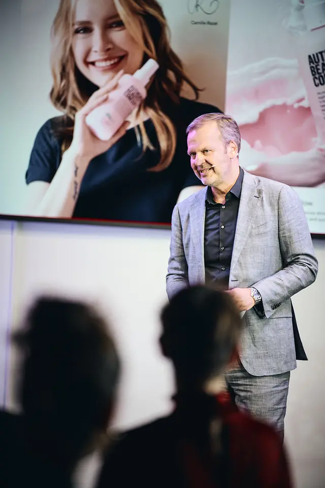 Lars Hennemann steht auf der Bühne und hält eine Rede. 