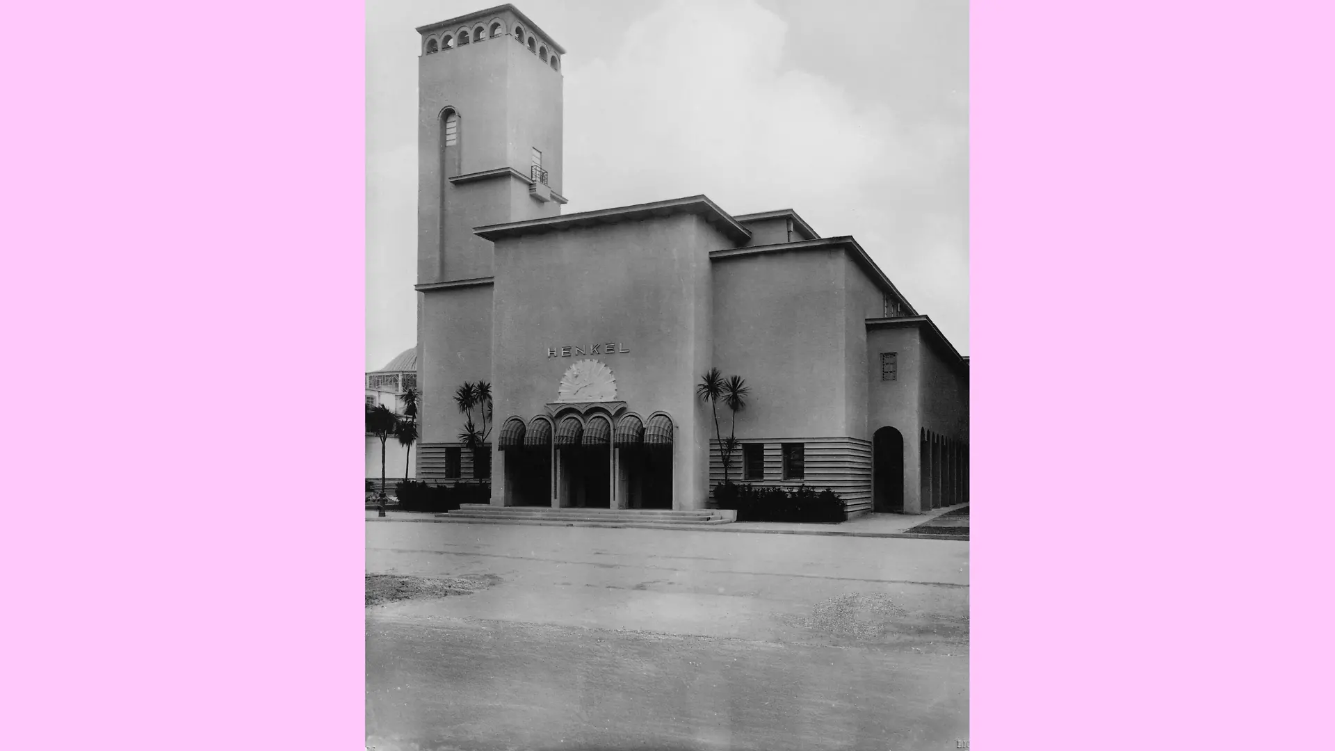 Außenansicht des sogenannten Gesolei Pavillons. Es handelt sich um ein einstöckiges Gebäude mit einem Turm auf der linken Seite. Über dem Eingang ist die Aufschrift "Henkel" angebracht.
