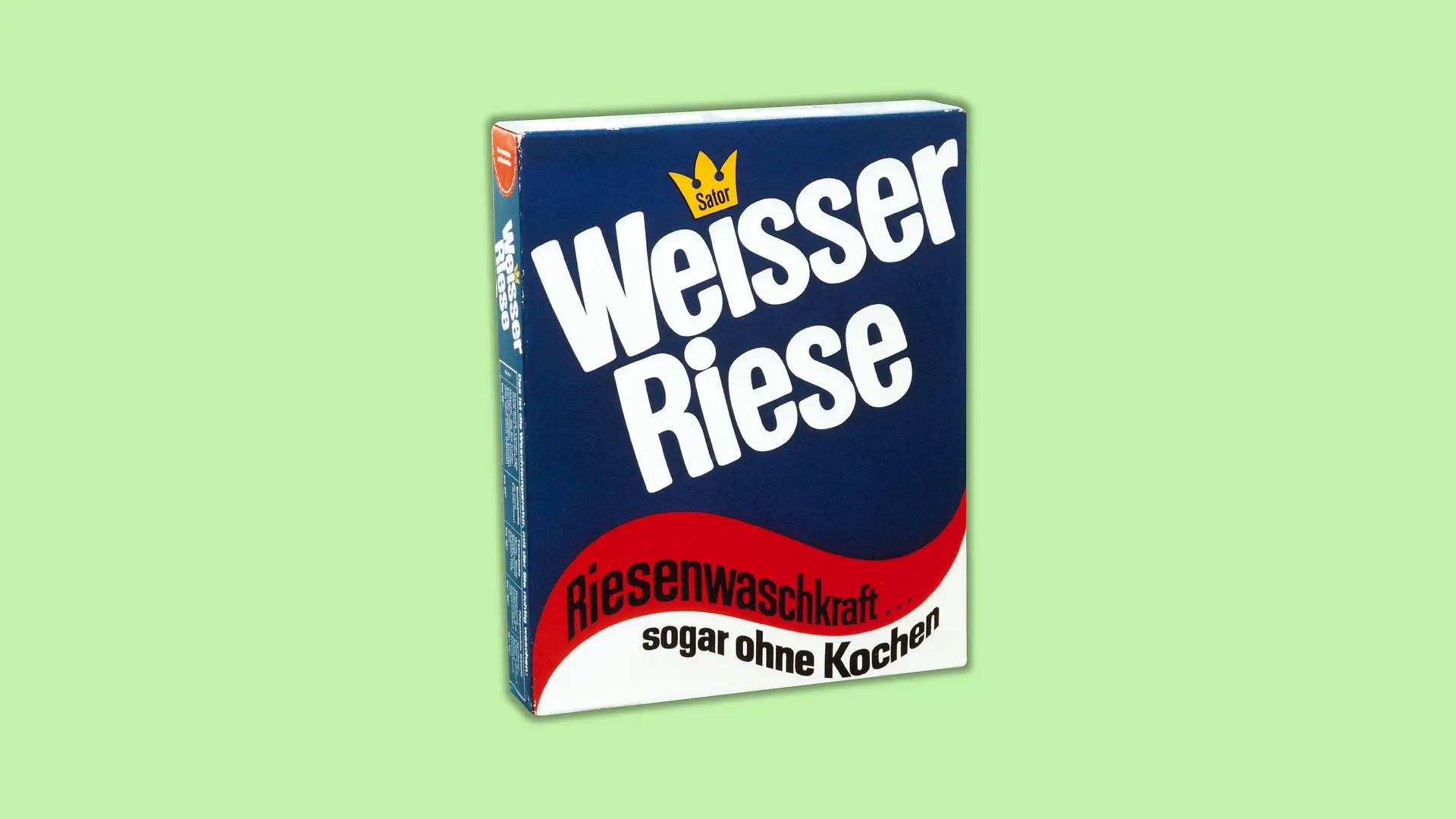 Verpackung des ersten Weißer Riese-Waschpulvers. Die Verpackung ist zu zwei Dritteln in einem dunklen blau gestaltet und schließt am unterem Ende mit untereinander gesetzten Wellenformen in rot und weiß ab. Der Markenname Weißer Riese ist prominent in großen weißen Buchstaben auf den blauen Hintergrund gesetzt. In der roten Wellenform beginnt der Slogan „Riesenwaschkraft...“, der in der weißen Wellenform mit “sogar ohne Kochen“ abschließt.