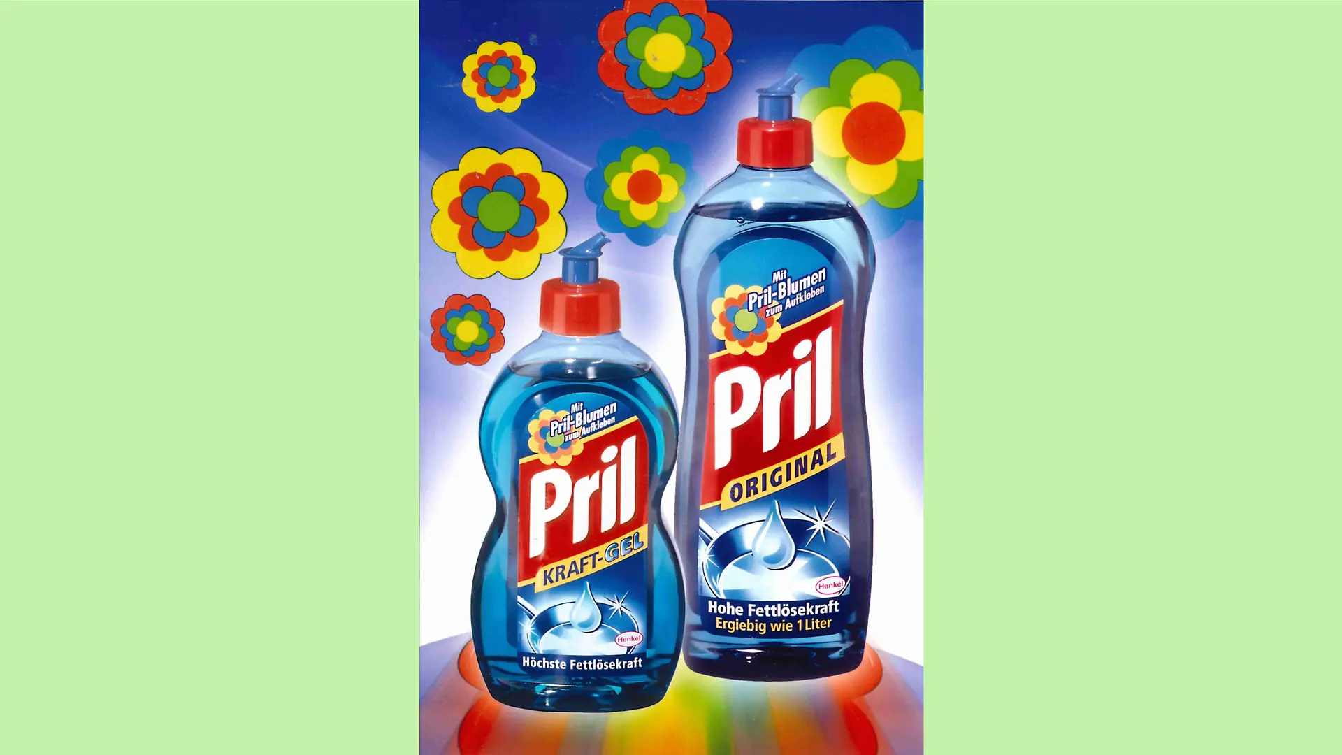 Werbemotiv mit einer Pril-Kraft-Gel und Pril-Original-Flasche auf einem von am oberen Rand mittel-blauen bis herunter ins weiße verlaufenden Hintergrund. Über den Flaschen sind bunte Pril-Blumen platziert.