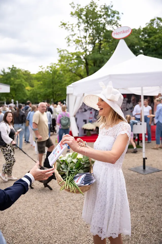 
Die weiße Dame von Persil verteilte Rosen an Besucher:innen.