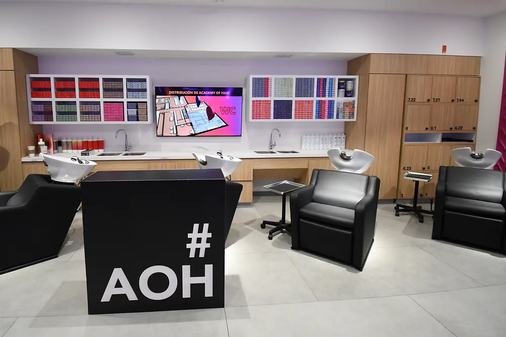 Auf dem Bild sind mehrere Waschsessel sowie Schränke mit verschiedenen Friseurprodukten in einem modern eingerichteten Salon zu sehen.