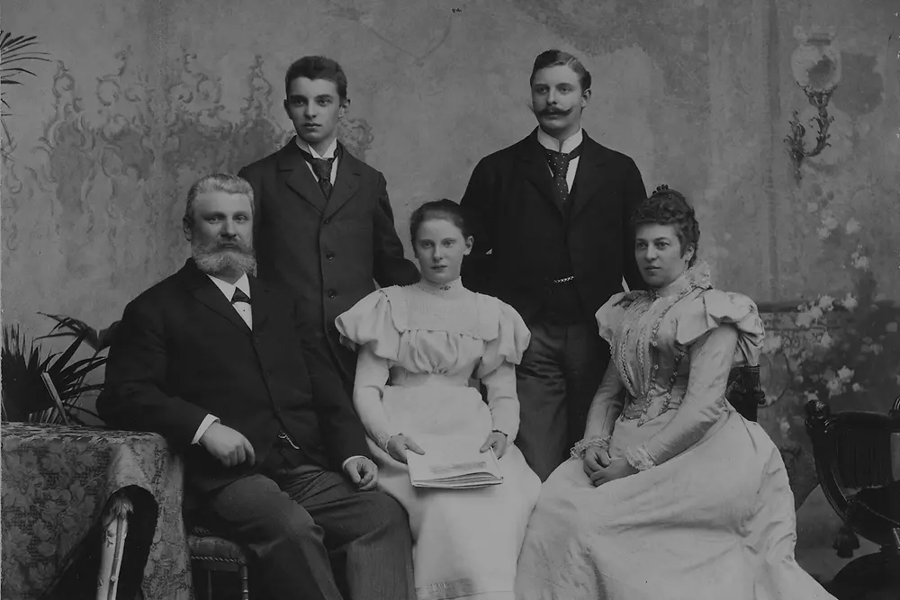Schwarz-weiß-Fotografie von Fritz Henkel mit seiner Familie um 1901. Die fünf Personen sitzen und stehen in festlicher Kleidung in einem Atelier-Setting.