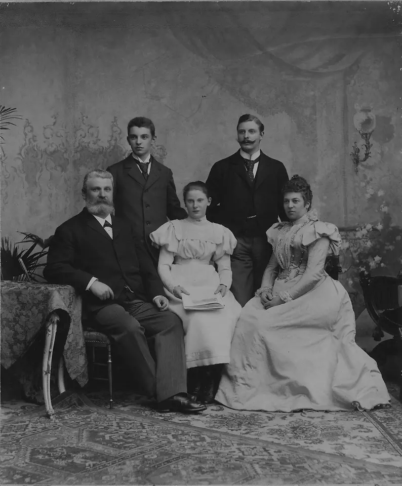 Schwarz-weiß-Fotografie von Fritz Henkel mit seiner Familie um 1901. Die fünf Personen sitzen und stehen in festlicher Kleidung in einem Atelier-Setting.