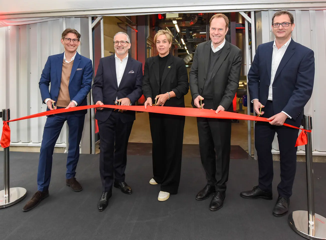 
Dr. Daniel Kleine, Carsten Knobel, Mona Neubaur, Dr. Stephan Keller und Julien Mounier bei der Eröffnung der Energiezentrale für das Fernwärme-Projekt von Henkel und den Stadtwerken (v.l.n.r.)
Copyright: Steffen Hauser