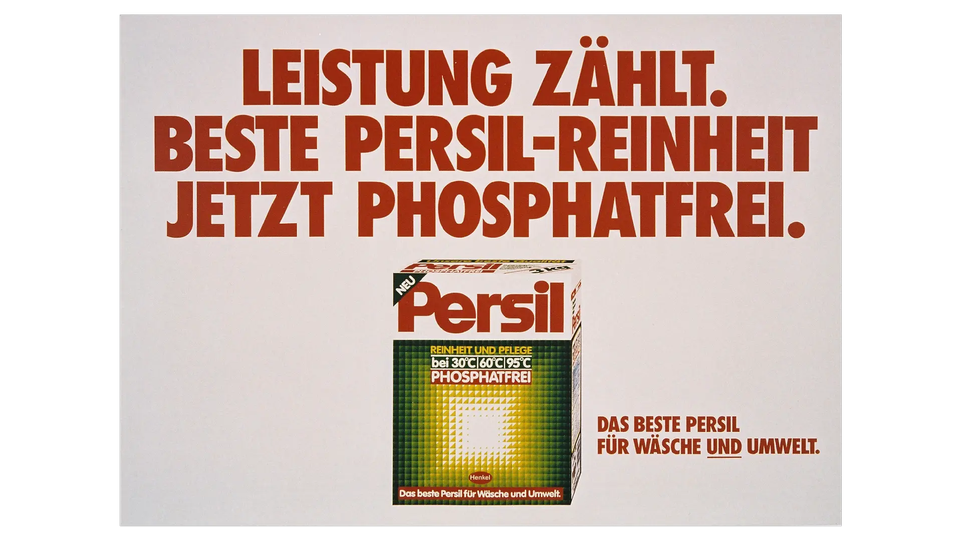 Eine historische deutsche Persil‑Anzeige vor hellem Hintergrund mit auffälliger roter und brauner Typografie und dem Text „Leistung zählt. Beste Persil‑Reinheit jetzt phosphatfrei.“ In der Mitte ist eine Persil‑Waschmittelpackung abgebildet.