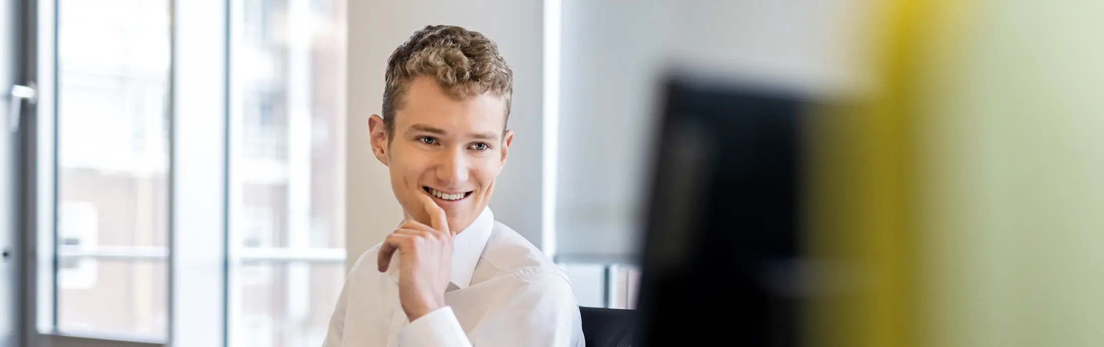 Ein Kollege blickt im Büro auf seinen Bildschirm