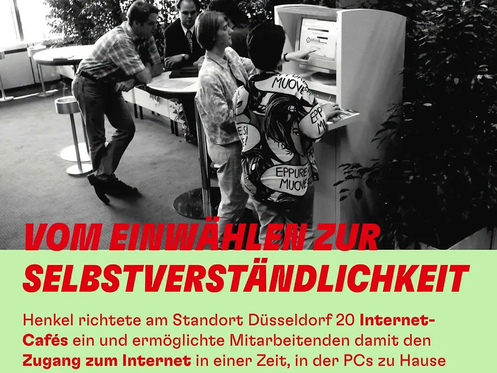 Schwarz-weißes Foto aus einem Innenraum mit mehreren Personen, die gemeinsam an einem großen, stationären Computerterminal stehen und sitzen. Auf dem Bildschirm ist eine Internetseite geöffnet. Einige Personen bedienen die Tastatur oder zeigen auf den Bildschirm, während andere zuschauen. Im Hintergrund sind weitere Sitzgelegenheiten und Pflanzen zu sehen. Im unteren Bereich des Bildes steht in großen roten Buchstaben: „VOM EINWÄHLEN ZUR SELBSTVERSTÄNDLICHKEIT“. Darunter wird beschrieben, dass Henkel in Düsseldorf 20 Internet-Cafés eingerichtet hat, um Mitarbeitenden den Zugang zum Internet zu ermöglichen. Die Jahreszahl „2001“ ist groß hervorgehoben.