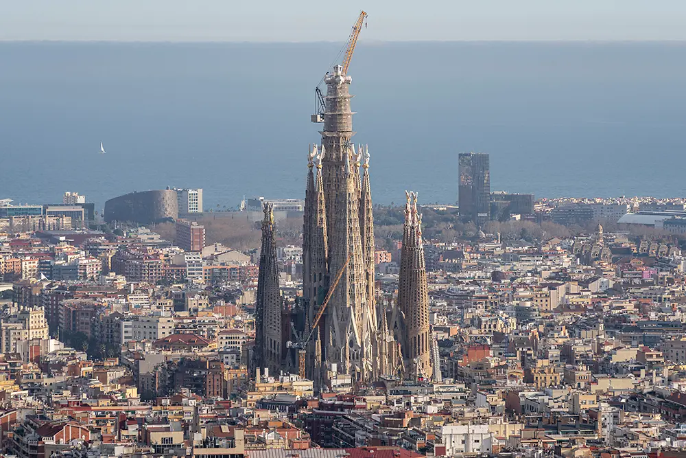 Cranes operating on the central towers with the Mediterranean Sea in the background