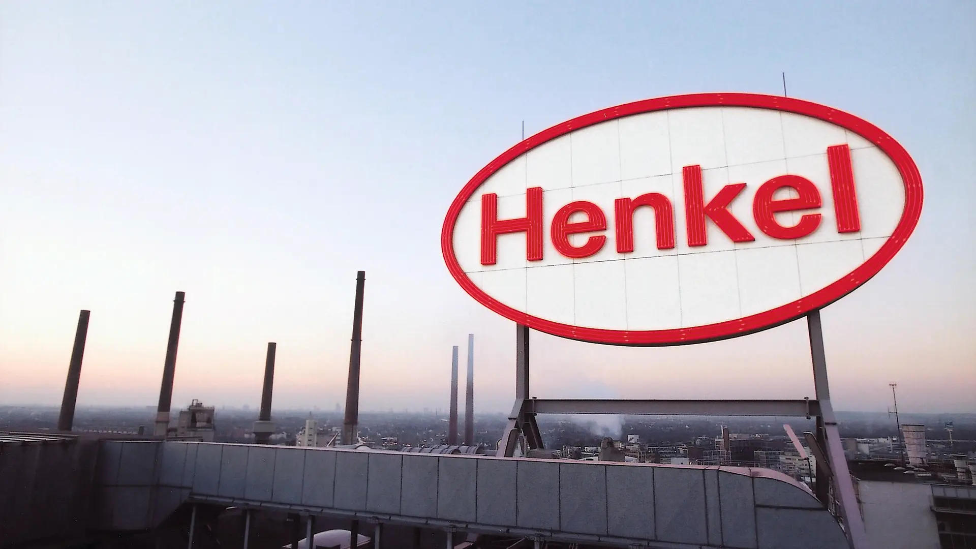 Henkel-Logo auf einem Dach mit Blick über das Werksgelände.
