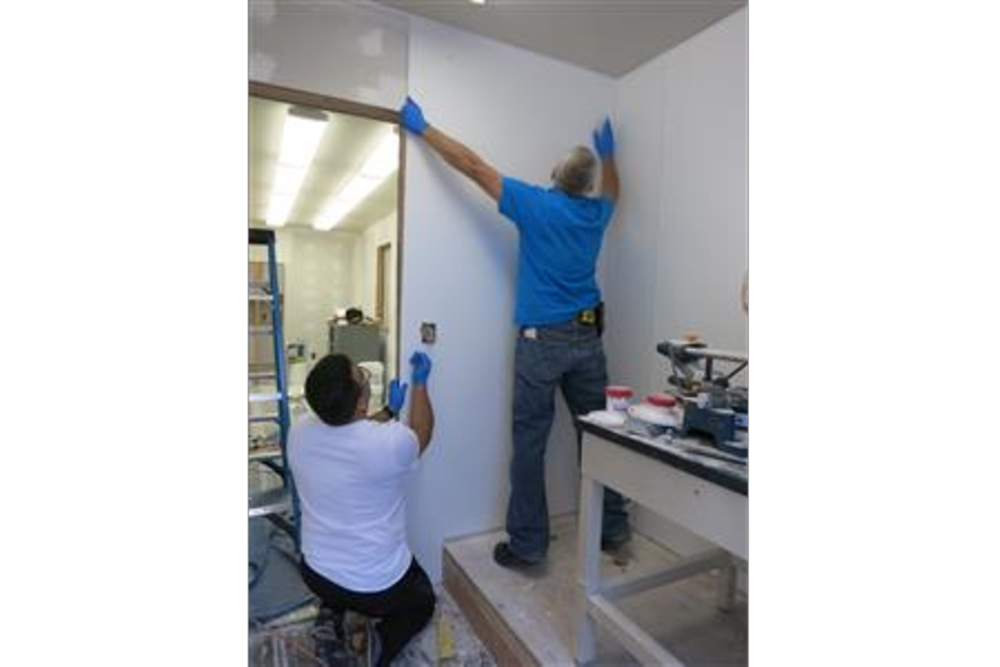 Employees install a plastic overlay 