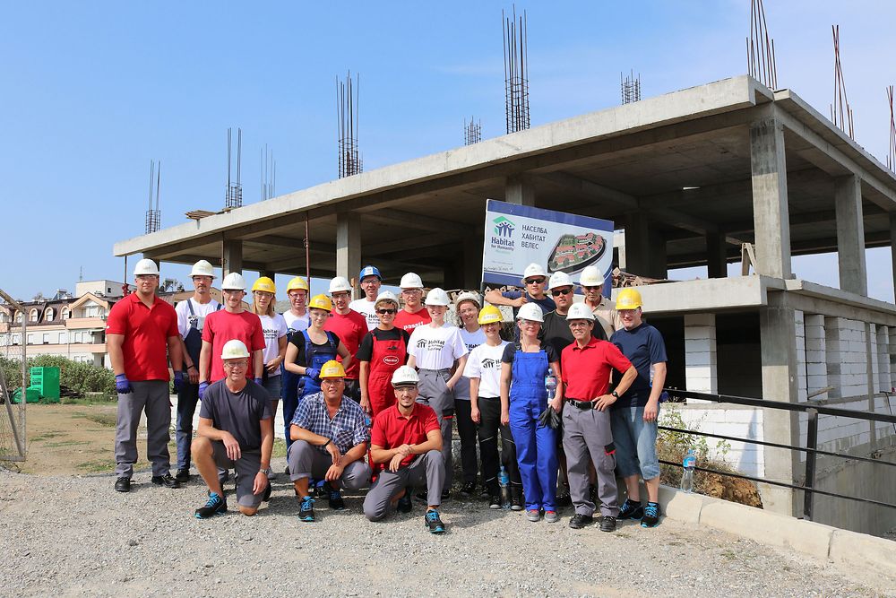 Die 22 Henkel-Mitarbeiter im mazedonischen Veles vor dem Rohbau des Mehrfamilienhauses 