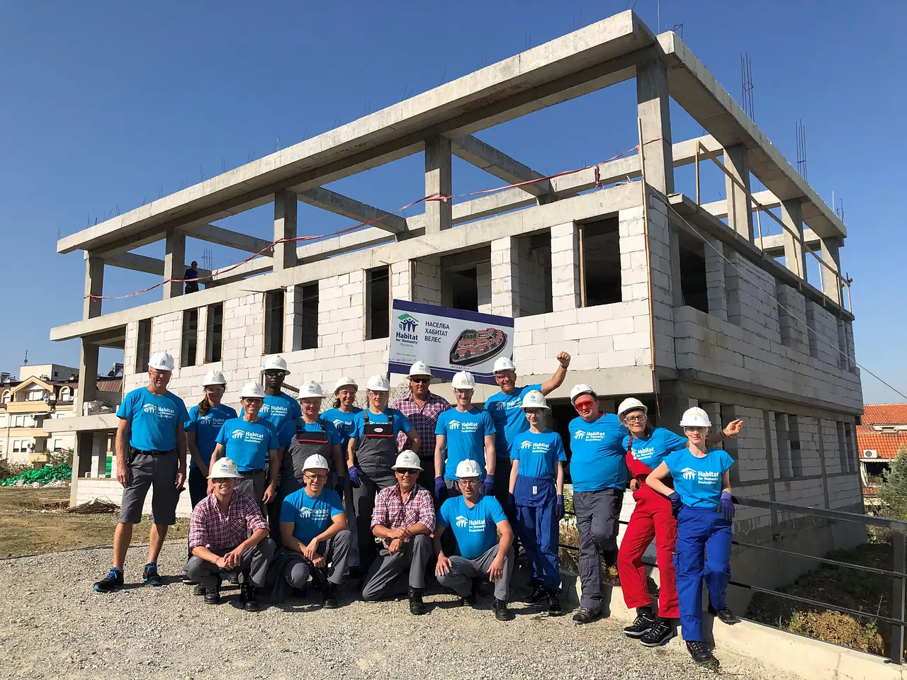Henkel-Mitarbeiter im mazedonischen Veles vor dem Rohbau des Mehrfamilienhauses